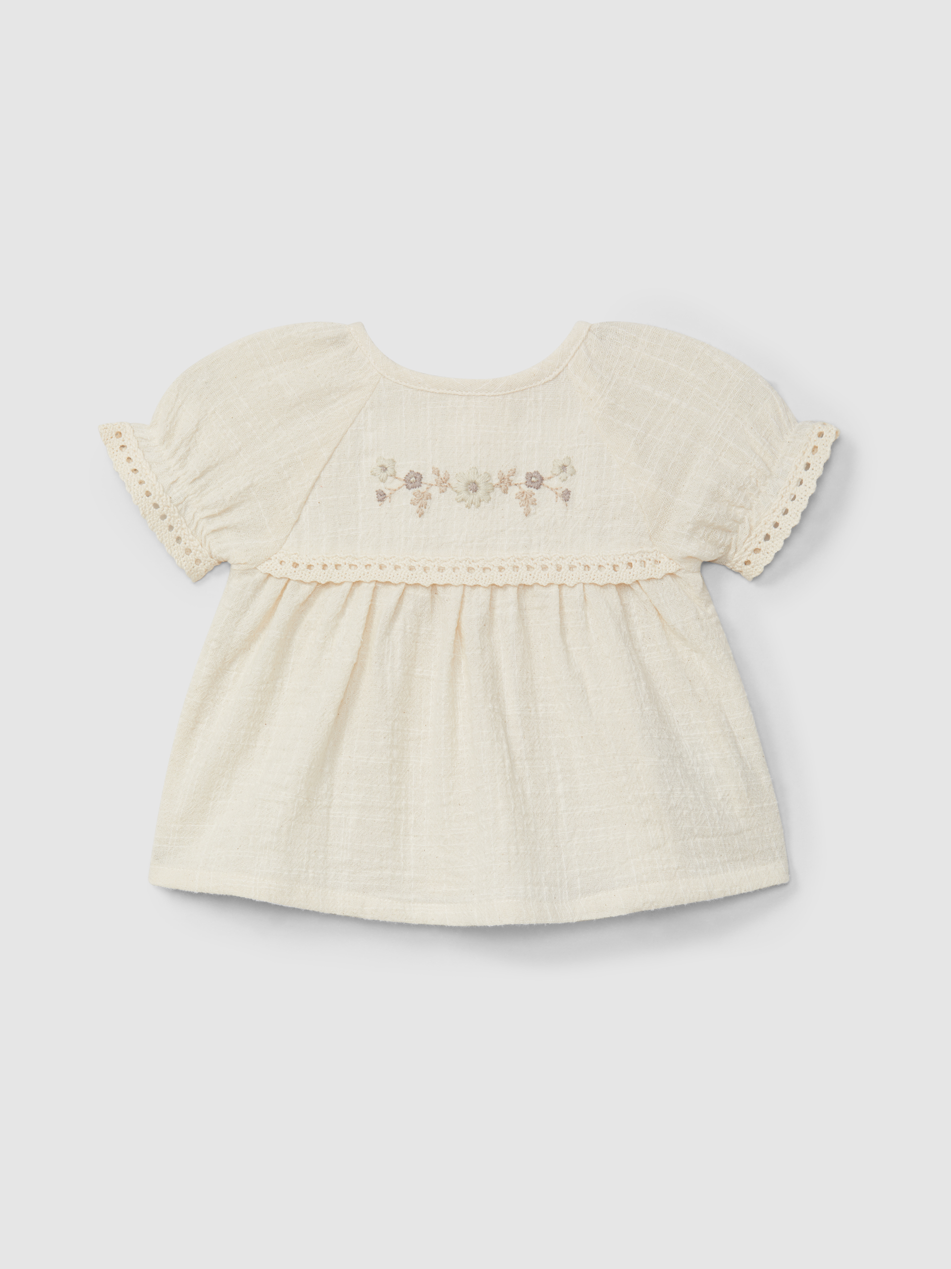 Conjunto de blusa y pantalón corto con bordado y detalles de encaje.