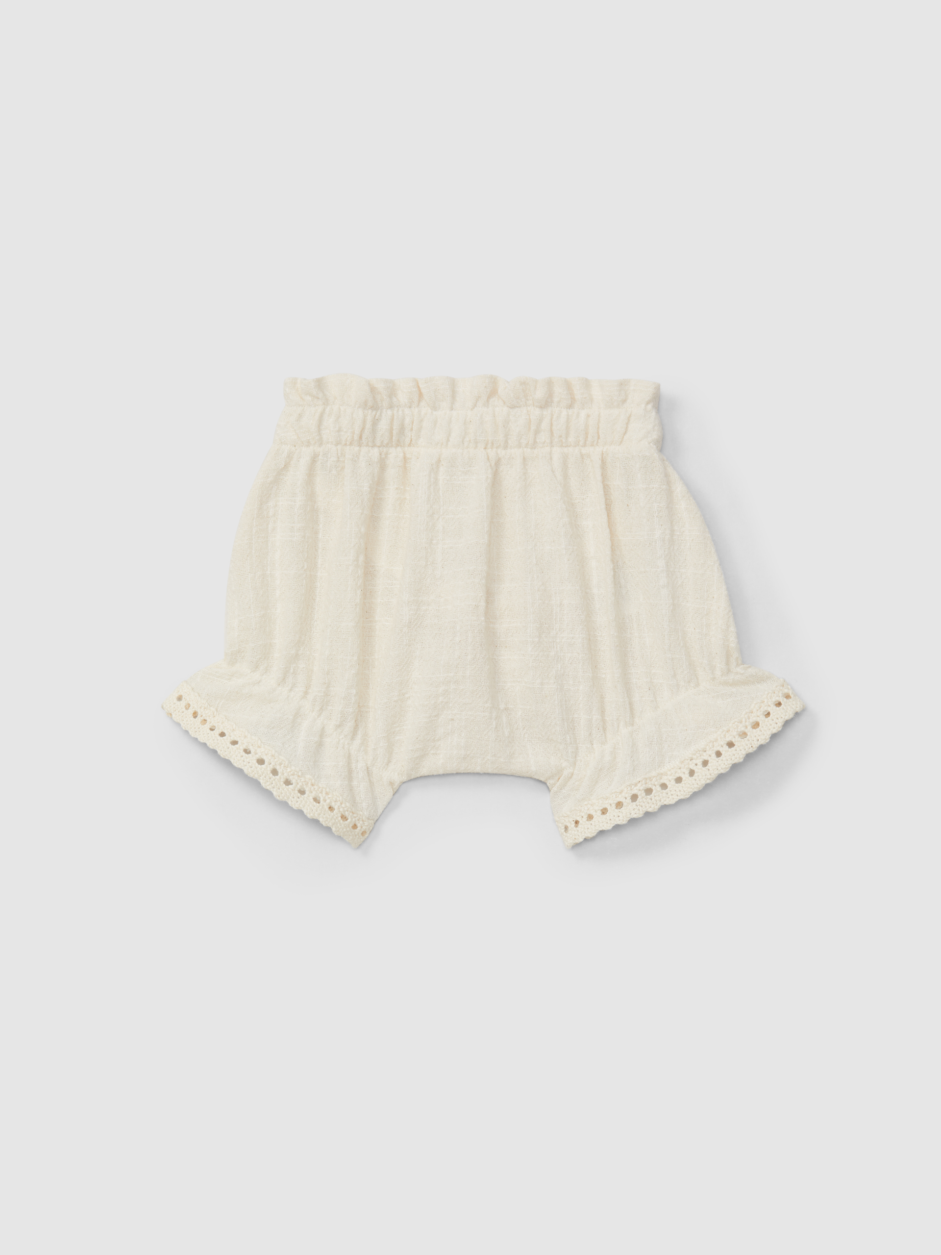 Conjunto de blusa y pantalón corto con bordado y detalles de encaje.