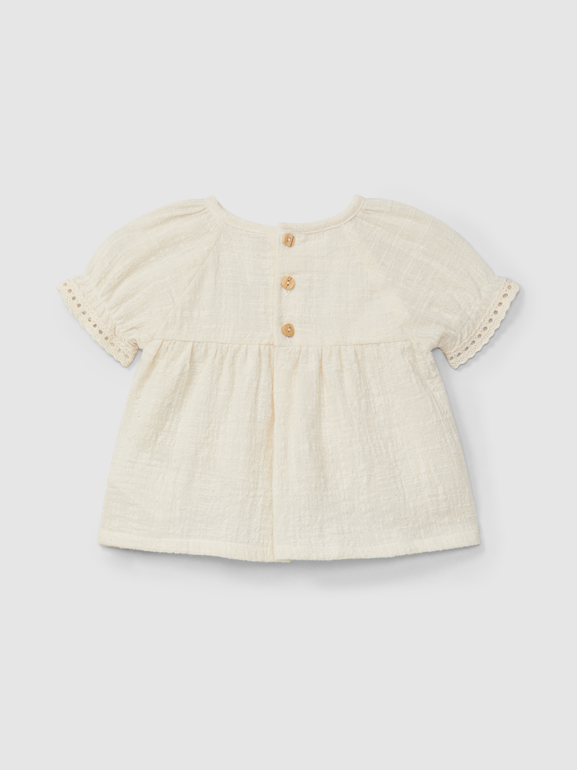 Conjunto de blusa y pantalón corto con bordado y detalles de encaje.